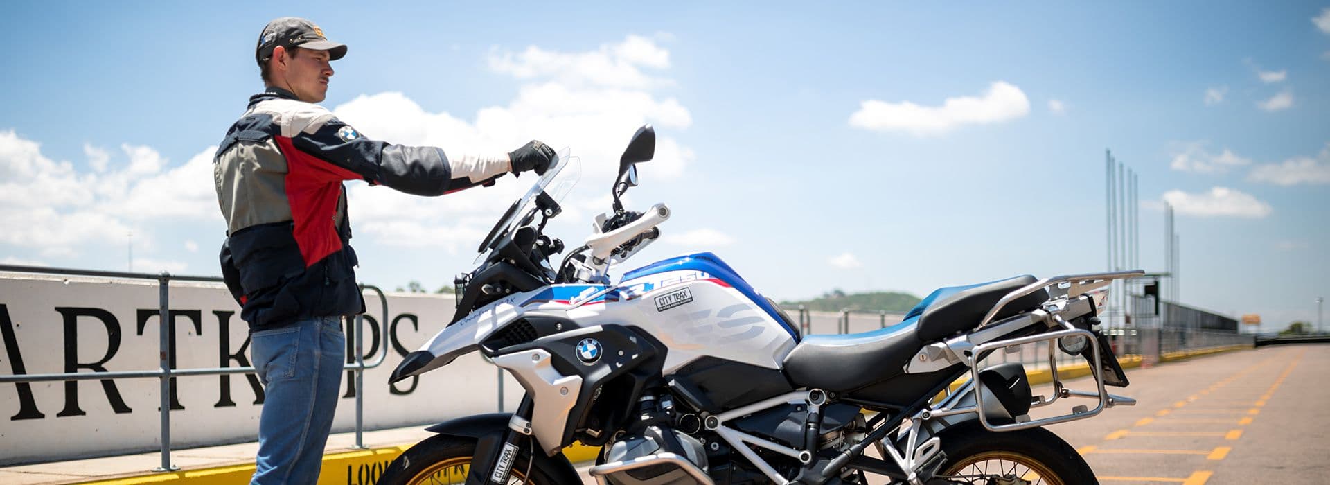 A CityTrax instructor demonstrating technique beside a BMW motorcycle at Zwartkops